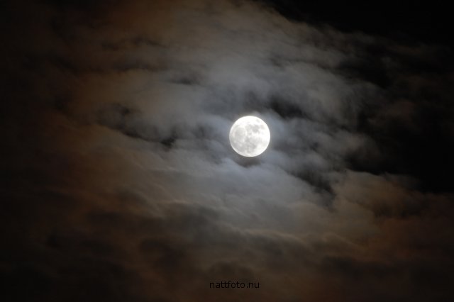 Fullmånen lyser genom moln